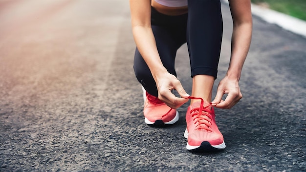 Scarpe da vicino corridore femminile che si lega le scarpe per un esercizio di jogging
