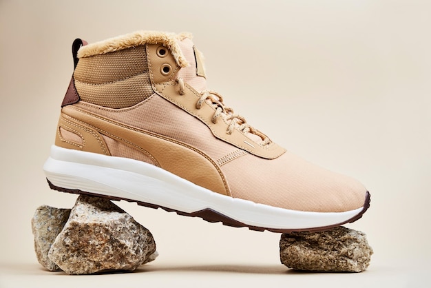 Scarpe invernali maschili su sfondo beige