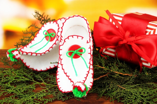 Scarpe natalizie decorative con regalo sul tavolo su sfondo luminoso