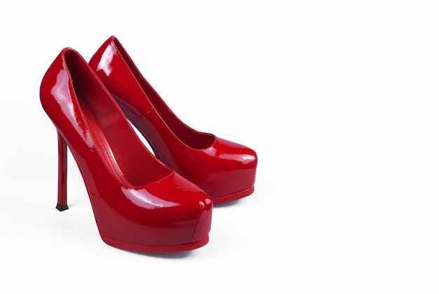 Scarpe rosse femminili su superficie bianca