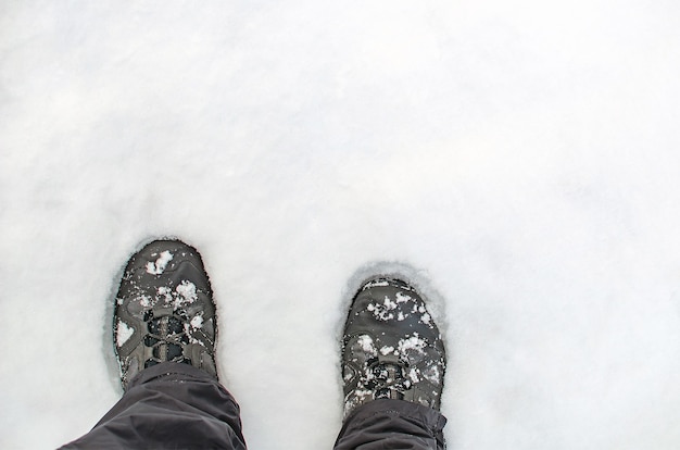 Scarponi nella neve, primo piano delle scarpe da trekking dall'alto, copia dello spazio.