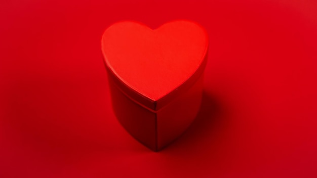 Scatola a forma di cuore su sfondo rosso
