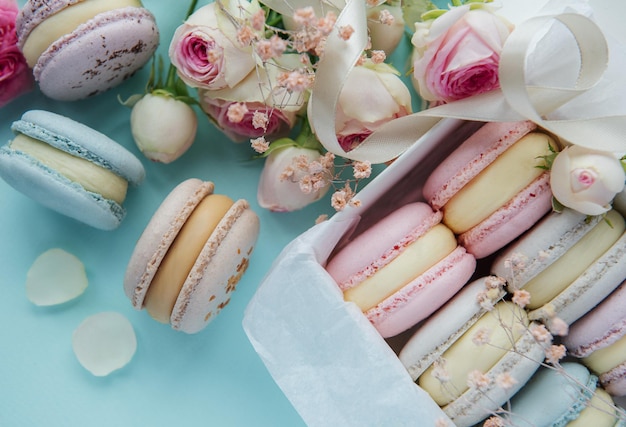 Scatola con deliziosi amaretti colorati e fiori di rosa