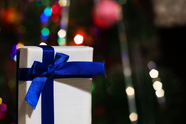 Scatola con un regalo sullo sfondo dell'abete di Capodanno