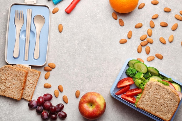 Scatola da pranzo con deliziosi frutti e mandorle su uno sfondo di leggera consistenza