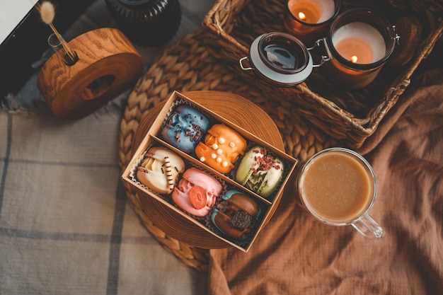 Scatola di amaretti con assortimento diverso e una tazza di caffè vista dall'alto in un'atmosfera familiare