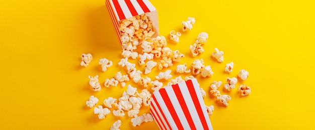 scatola di cartone con popcorn su uno sfondo giallo di primo piano