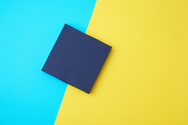 Scatola di cartone di carta blu scuro chiusa su un giallo-blu