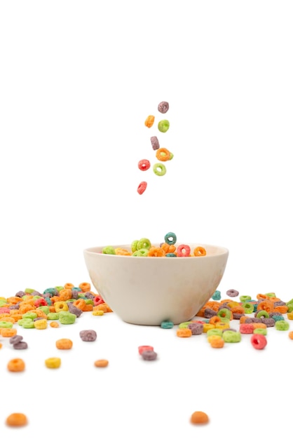 Scatola di cereali colorata per la colazione mattutina. Fiocchi di mais che cadono nella ciotola bianca. Movimento. Copyspace.