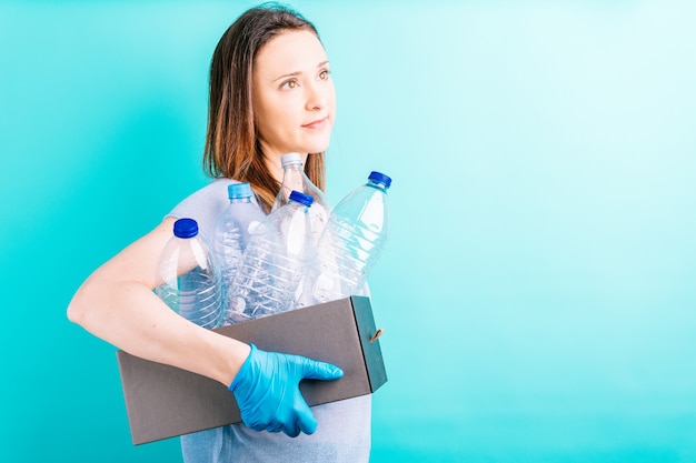 Scatola di contenimento della mano della donna con bottiglie di plastica per il riciclaggio. concetto di riciclaggio. cura dell'ambiente