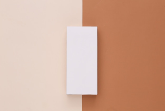 Scatola di imballaggio bianca aperta su beige marrone. minimalismo