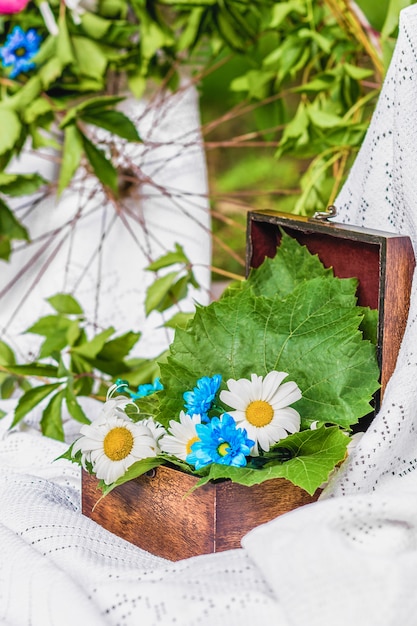 Scatola di legno aperta decorata con infusioni e foglie fresche