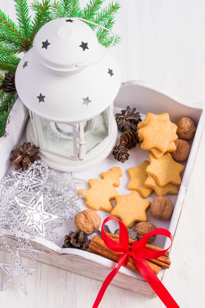 Scatola di legno bianca con biscotti fatti in casa e decorazioni natalizie