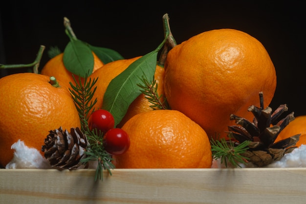 Scatola di legno con arance, rami di abete e pigne. Natale ancora vita.