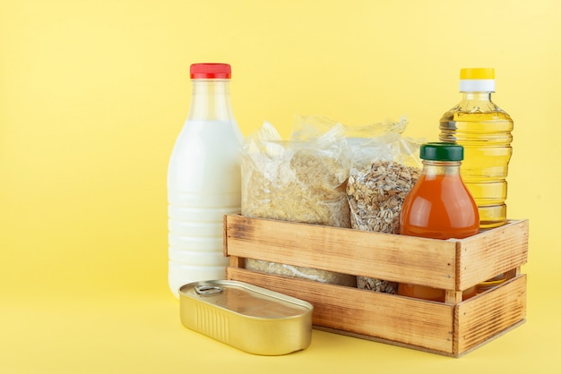 Scatola di legno con cibo in scatola e bottiglie