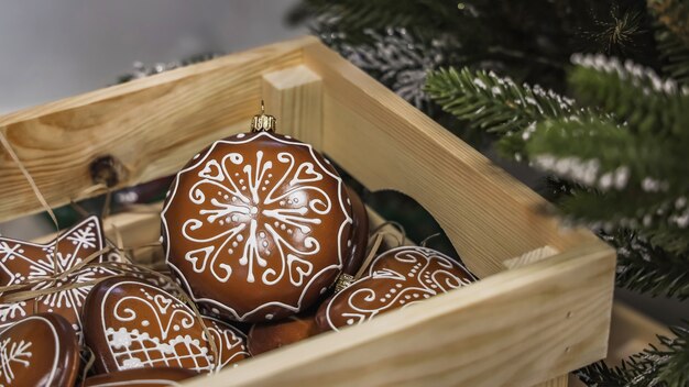 Scatola di legno con palline decorative natalizie fatte a mano e giocattoli sui rami verdi del pino