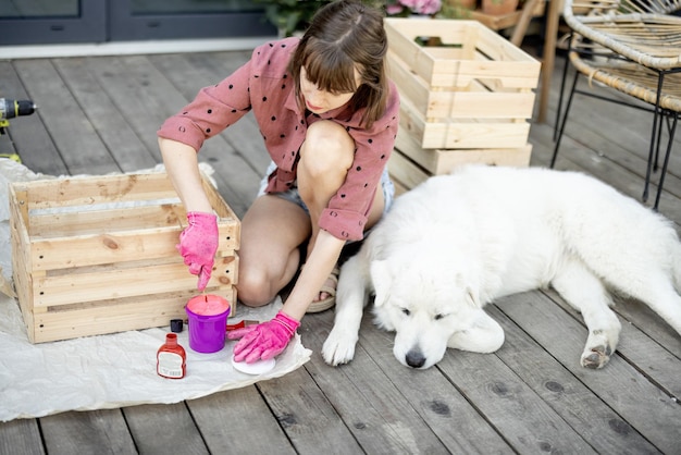 Scatola di legno della pittura della donna che si siede con il cane sulla terrazza