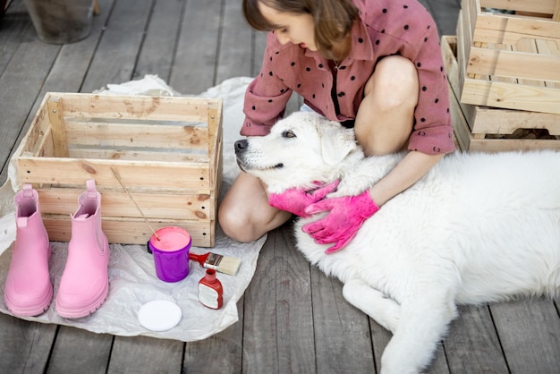 Scatola di legno della pittura della donna che si siede con il cane sulla terrazza