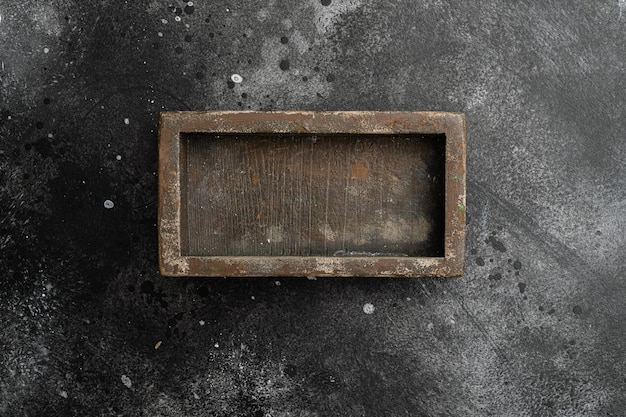 Scatola o contenitore in legno rustico con spazio per copia per testo o cibo, vista dall'alto piatta, su sfondo nero tavolo in pietra scura