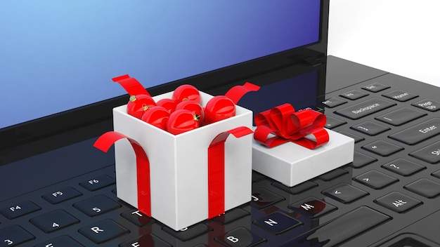 Scatola regalo aperta piena di palle di Natale sulla tastiera del computer portatile