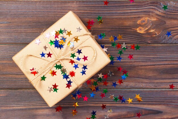 scatola regalo con decorazione a forma di stella sullo sfondo di un tavolo di legno bianco