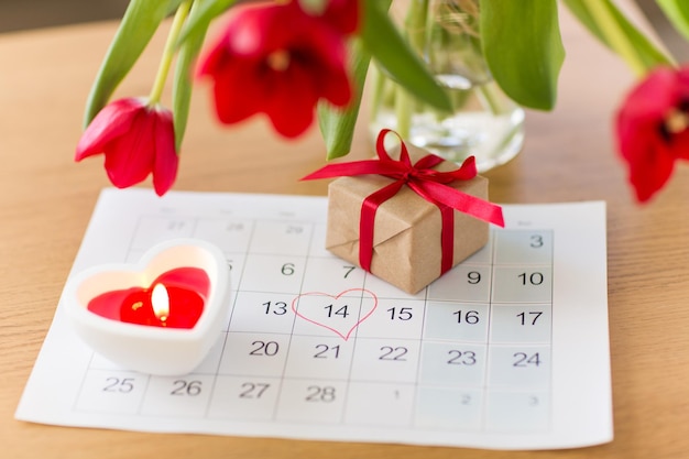 scatola regalo foglio di calendario e fiori su tavola