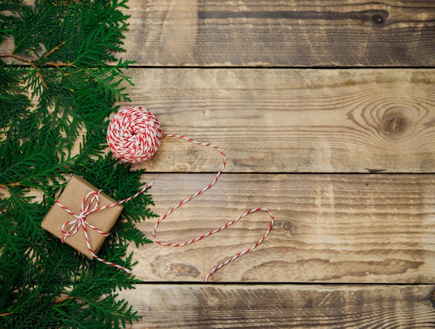Scatole confezionate in carta kraft e rami verdi su fondo in legno. Natale e Capodanno.