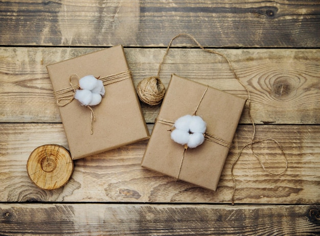 Scatole confezionate in carta kraft, spago su fondo in legno. Materiale ecologico. Natale e Capodanno.