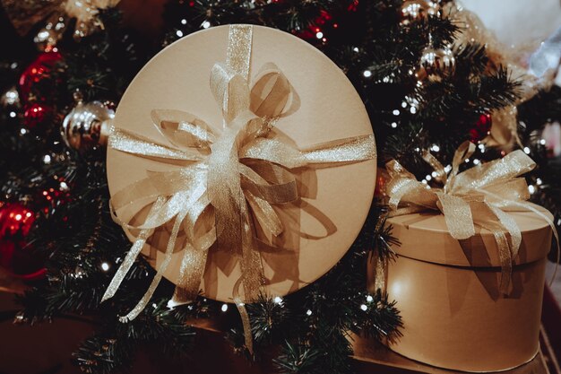 Scatole d'oro regali con nastri su un albero di Natale Decorazione per feste o cartoline