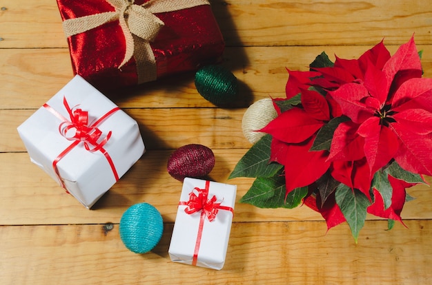 Scatole da regalo e fiore di Natale su un tavolo di legno