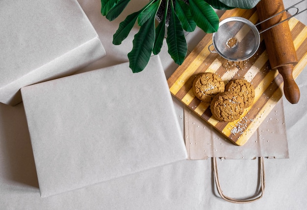 Scatole imballate Shopping Bag per la consegna di cibo e pianta verde su sfondo grigio vista dall'alto