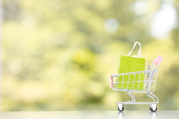 Scatole pacchetto prodotto nel carrello con shopping bag