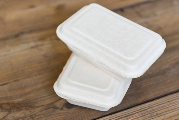 Scatole per alimenti da asporto, contenitori per imballaggi ecologici usa e getta sul tavolo di legno a casa