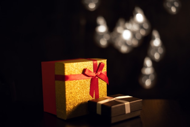 Scatole regalo al buio con luci bokeh di una ghirlanda di Natale