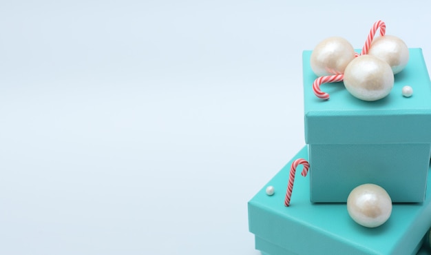 Scatole regalo blu con bastoncini di Natale, perle grandi e piccole su bianco