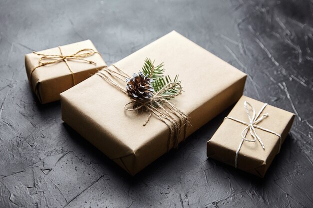 Scatole regalo con rami e coni verdi dell'albero di Natale su sfondo scuro