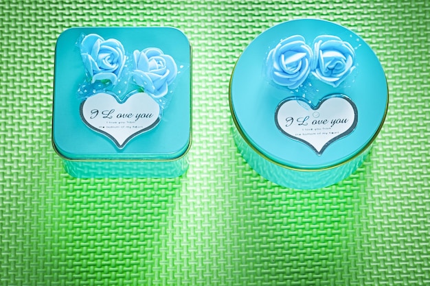 Scatole regalo confezionate in metallo blu su sfondo verde vista dall'alto concetto di celebrazioni
