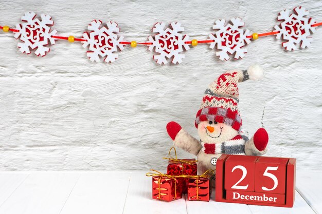 Scatole regalo decorative dell'albero di Natale e calendario di legno su fondo di legno bianco