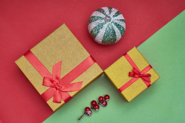 Scatole regalo, decorazioni natalizie su sfondo di carta verde e rosso. Foto alla moda. Anno nuovo, concetto di natale Copia spazio