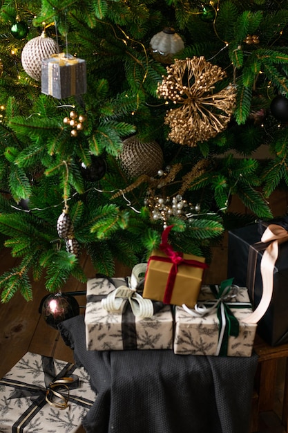 Scatole regalo di lusso sotto l'albero di Natale Decorazioni per la casa di Capodanno avvolgimento di Babbo Natale presenta un albero festivo decorato con palline di ghirlanda tradizionale celebrazione verticale