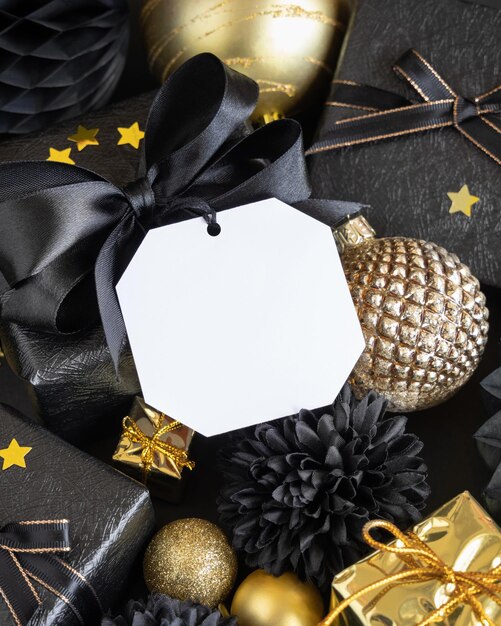 Scatole regalo di Natale nere e dorate e ornamenti con etichetta regalo quadrata Mockup