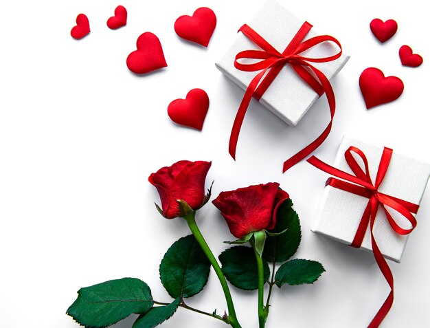 Scatole regalo di San Valentino e rose rosse su una superficie bianca