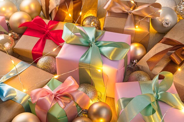 Scatole regalo e palline di Natale alla luce di una ghirlanda. Il concetto di Natale e Capodanno. Vista laterale.