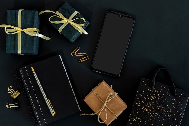 scatole regalo in cartone e nero con smartphone e borsa concetto Black Friday