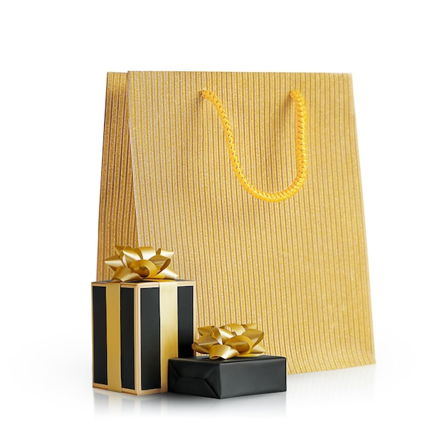 scatole regalo in confezione nera accanto a un pacchetto vacanze dorato.