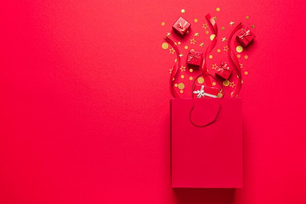 Scatole regalo rosse e una borsa della spesa Concetto di regalo con regali e coriandoli