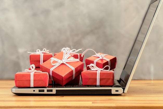 Scatole regalo rosse impilate su laptop o computer