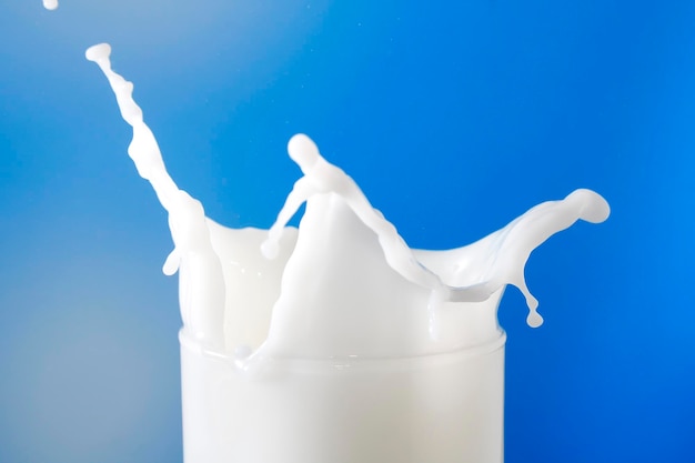 Scatta una foto del latte che si frantuma dallo sfondo di vetro blu
