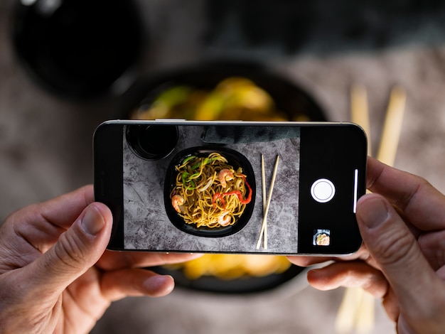 Scattare una foto con smarpthone di cibo asiatico