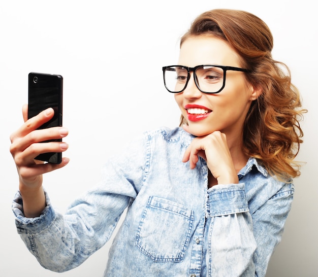 Scattare una foto. Donna bionda allegra sorridente che fa selfie